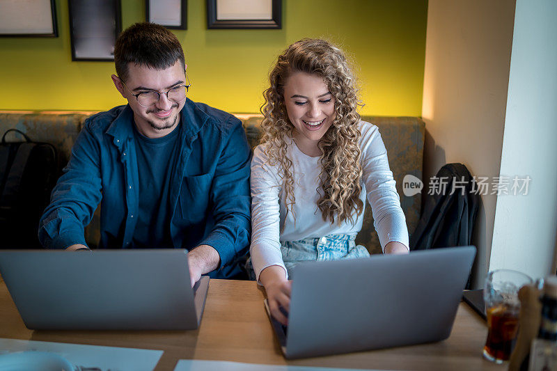 Business people working together at a café using their laptops